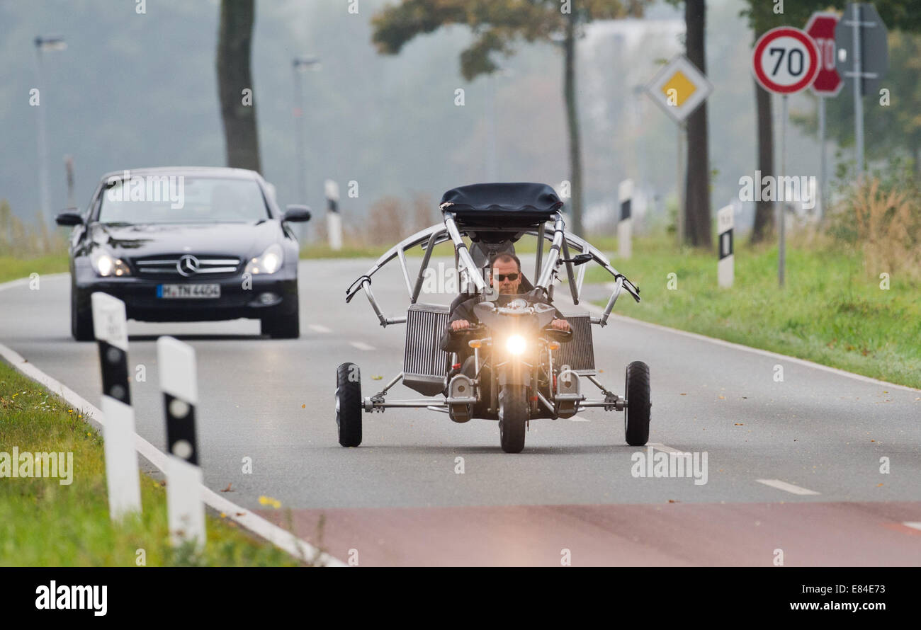 Bissendorf, Deutschland. 30. September 2014. Michael Werner von der Firma Fresh Breeze fährt einen Prototyp eines fliegenden Auto über eine Straße in der Nähe von Bissendorf, Deutschland, 30. September 2014. Drei Räder, zwei Sitze, einen Propeller und einem Segelflugzeug Flügel, frische Brise ein fliegendes Auto entwickelt die auf den Straßen gefahren werden darf. Foto: JULIAN STRATENSCHULTE/Dpa/Alamy Live News Stockfoto