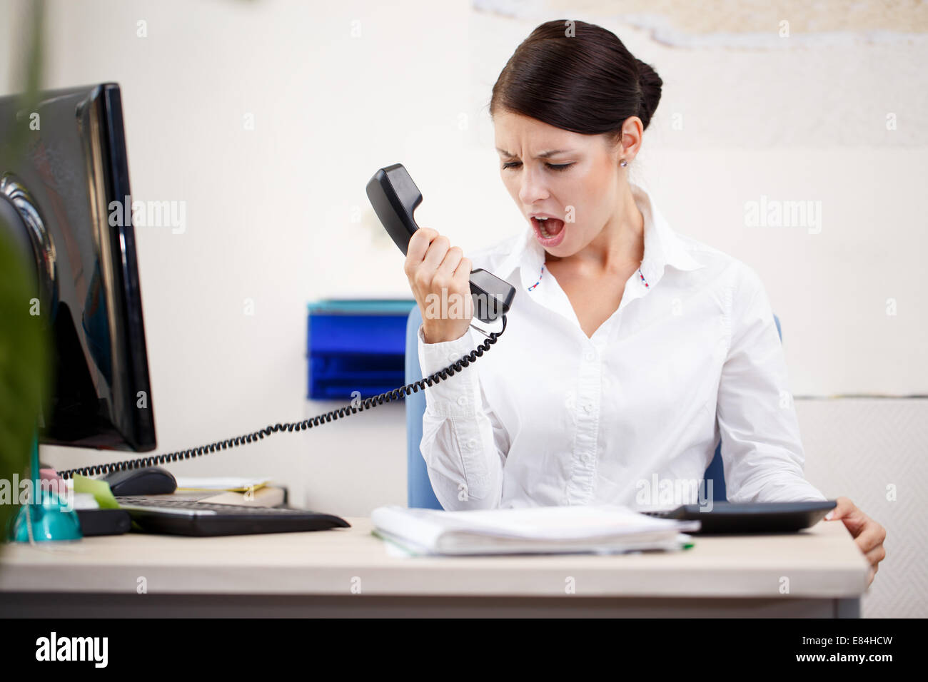 Böse Frau schreiend an Telefon Stockfoto