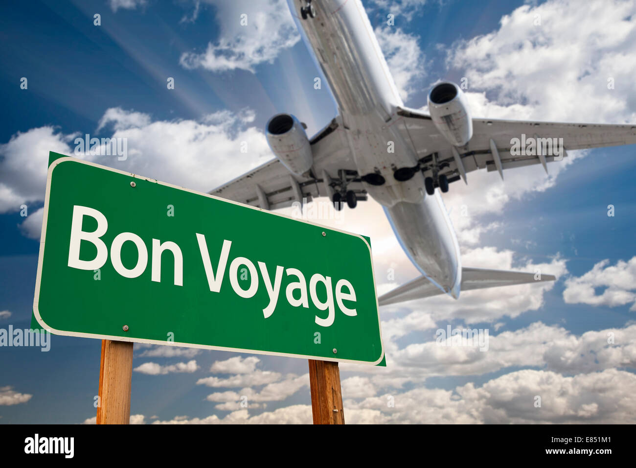 Bon Voyage grün Straßenschild und Flugzeug über dramatische blauer Himmel mit Wolken. Stockfoto