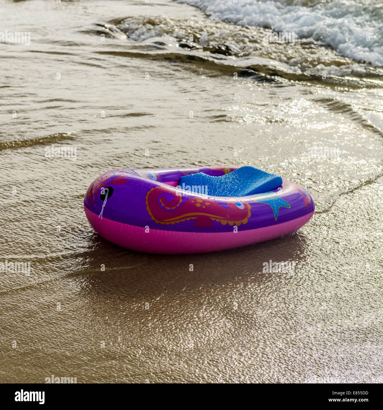 Aufblasbare Plastik eines Kindes schlagen schwimmt frei auf einem tropischen Strand. Stockfoto