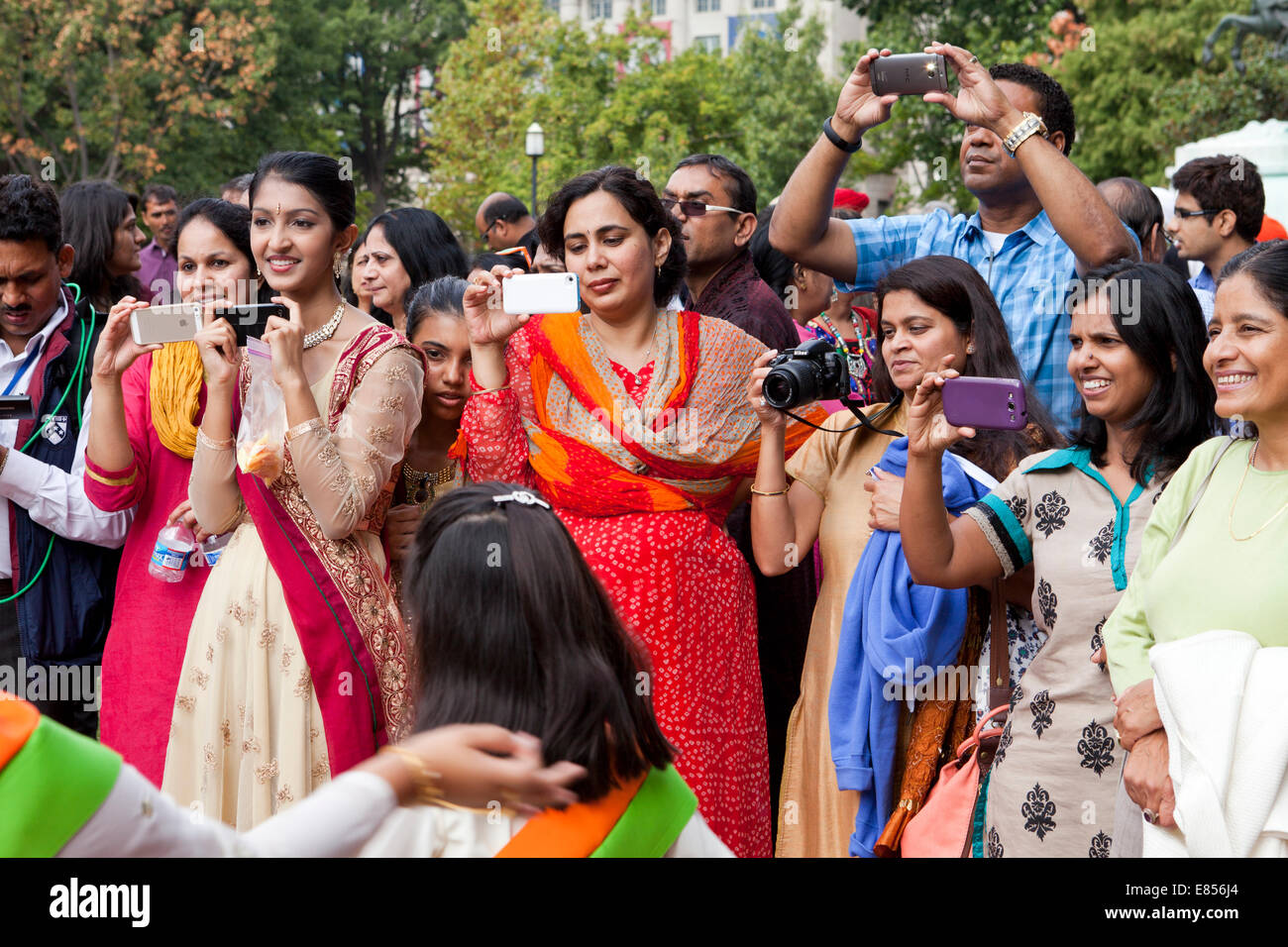 Indische Frauen Video taping ein Ereignis mit Smartphone - USA Stockfoto