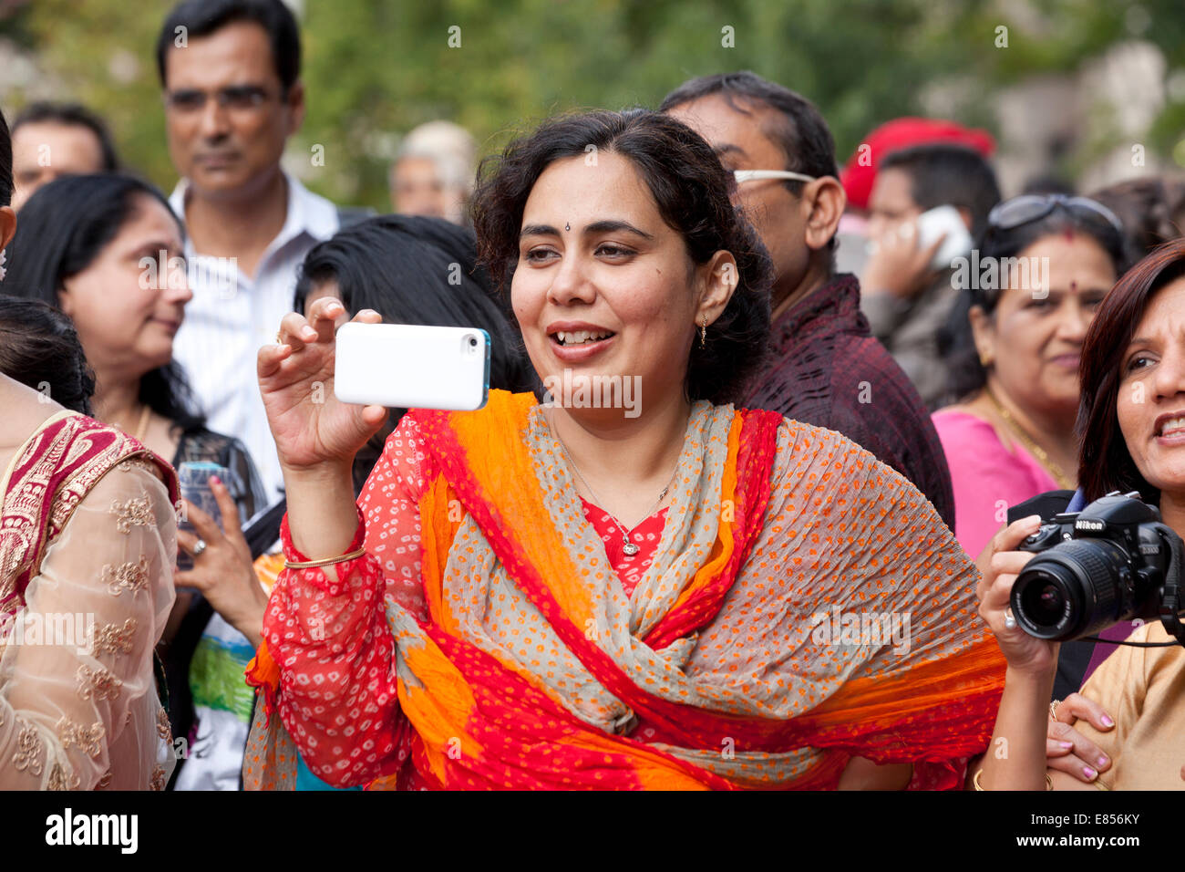 Indische Frau Video taping ein Ereignis mit Smartphone - USA Stockfoto