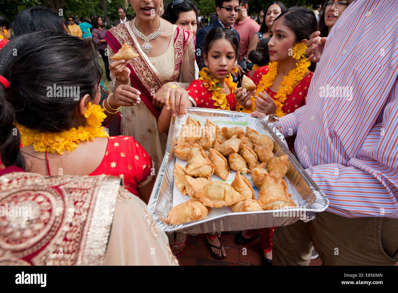 Menschenmenge versammelte sich um eine Platte des indischen Samosas Stockfoto