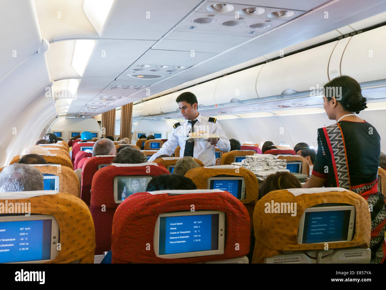 Steward und Stewardess serviert Mahlzeiten auf Air India Airlines Flug Stockfoto