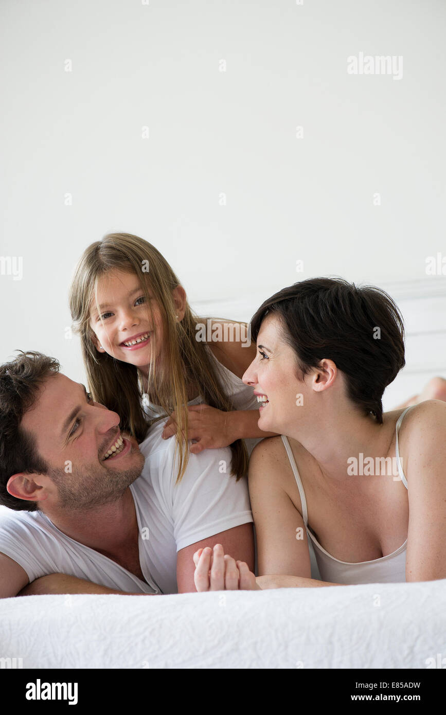 Eltern und Tochter gemeinsam auf Bett liegend, portrait Stockfoto