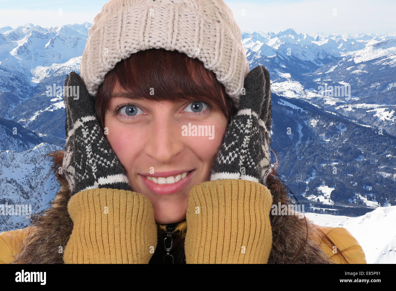 Porträt einer jungen Frau frieren in der Kälte im Winter mit Handschuhen und Mütze in den Bergen Stockfoto
