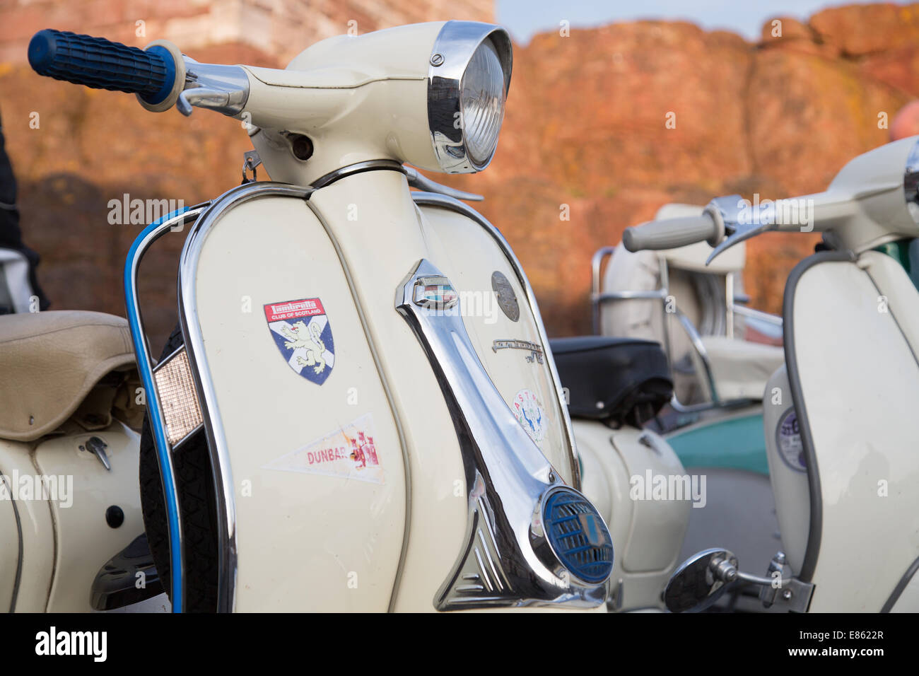 Oldtimer Motorroller, Vespas und Lambrettas zusammen außerhalb geparkt Stockfoto