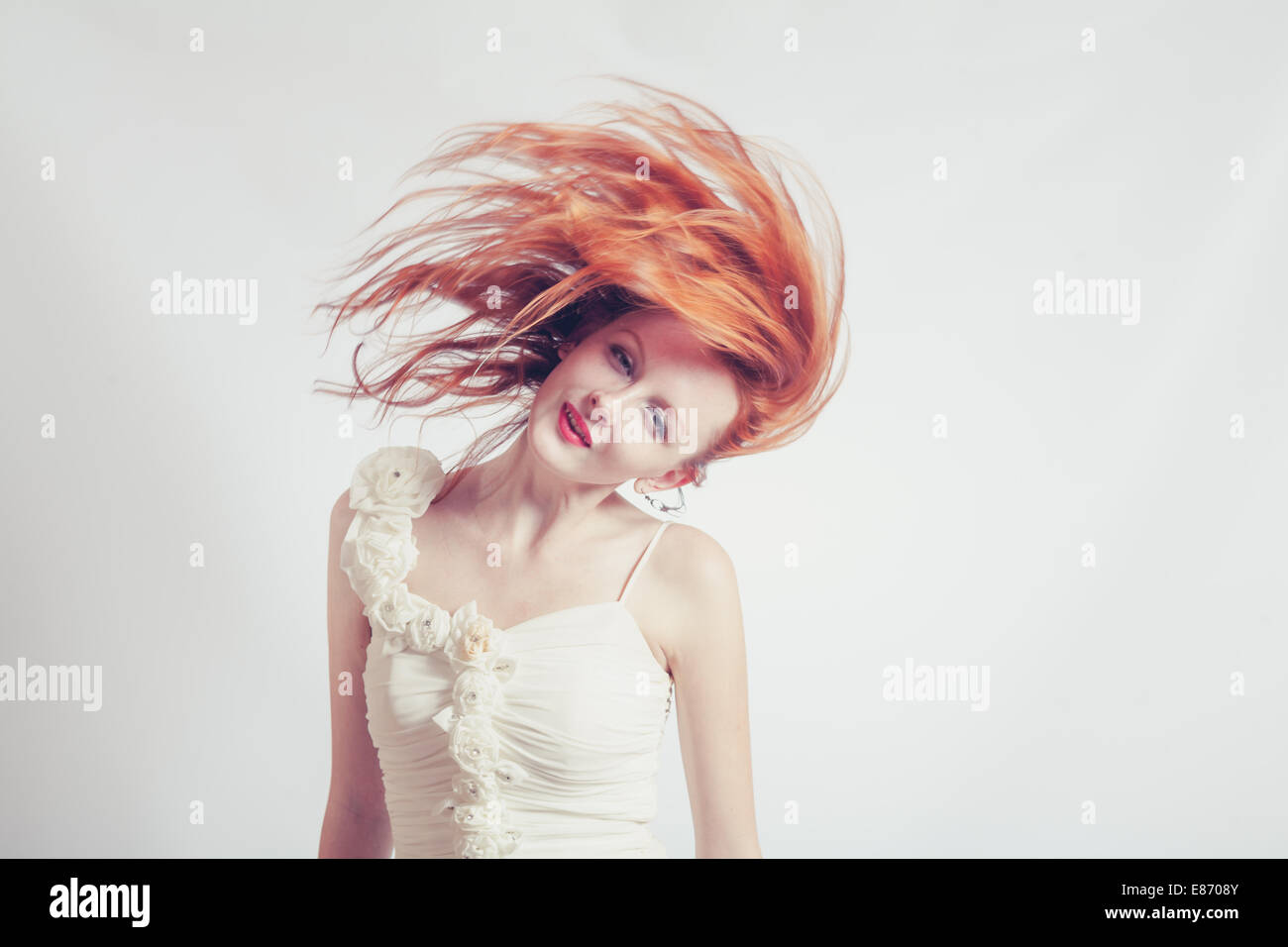 Getönten Schuss roten Haaren expressive emotionale Frau mit fliegenden Haare auf Studio-Hintergrund Stockfoto