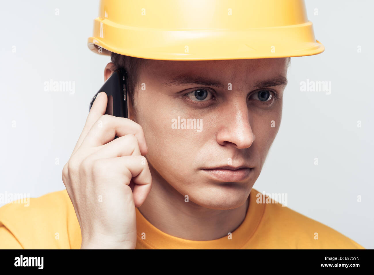 Männliche Arbeiter telefonieren mit Handy Stockfoto