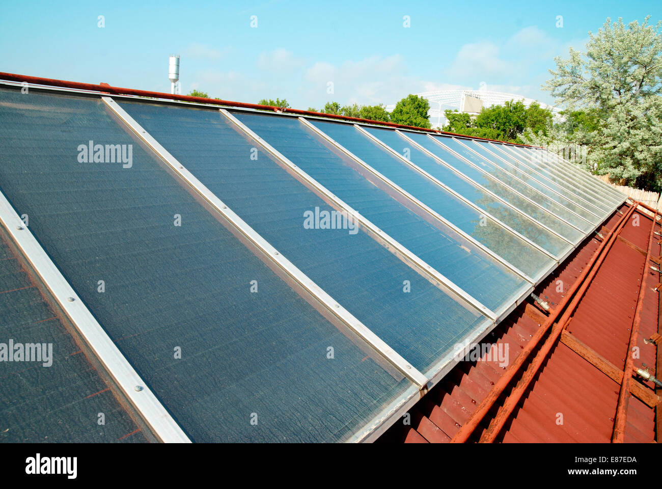 Heisses Wasser mit Sonnenenergie auf dem roten Dach. Gelio Platten. Stockfoto