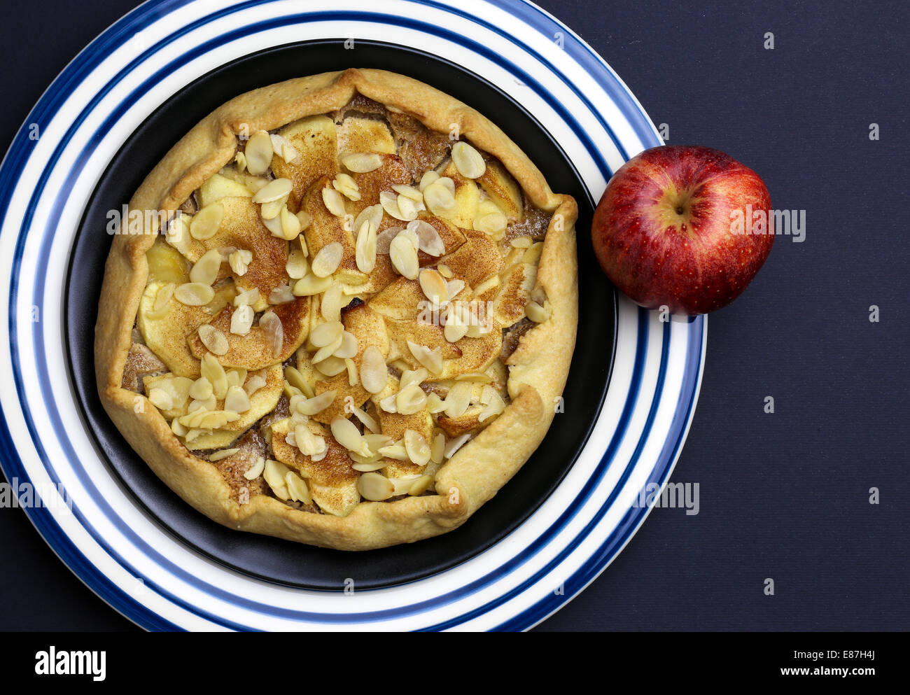 Galette Crostata süßen Kuchen Apfelkuchen auf schwarz und blau gestreifte Platte auf dunklem Hintergrund Stockfoto