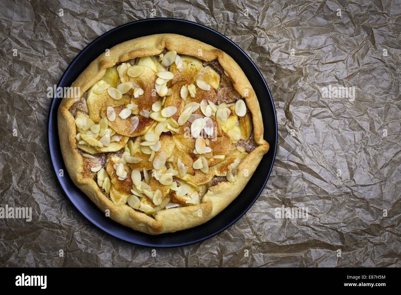 Galette Crostata süßen Kuchen Apfelkuchen auf schwarzen Wüste Druckplatte auf faltige Trägerpapier Stockfoto
