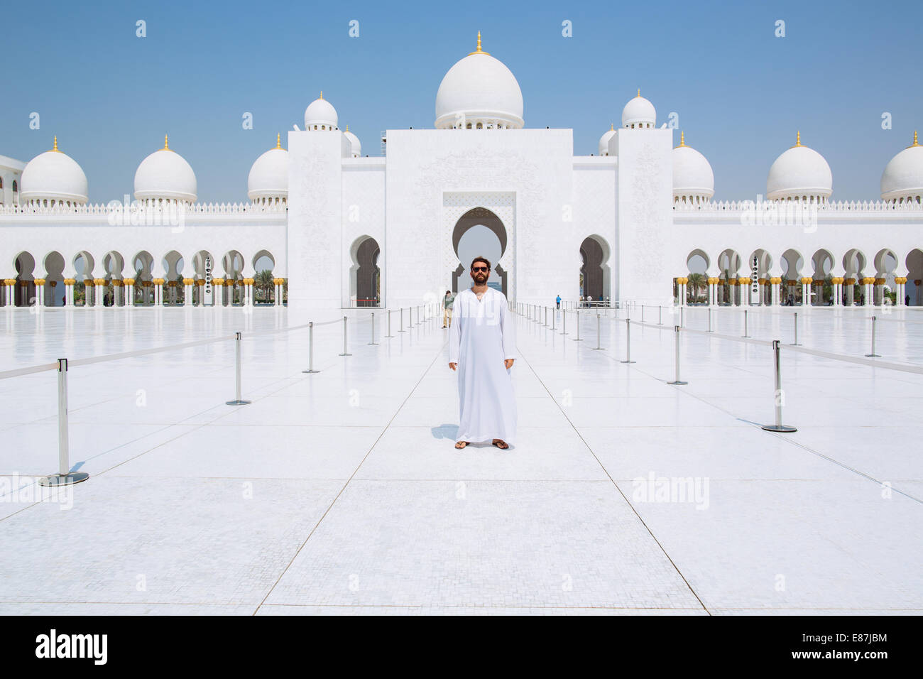 Abendländischen Mann gekleidet mit in ein Thobe in Abu Dhabi Sheikh Zayed Grand Moschee inneren Hof Stockfoto