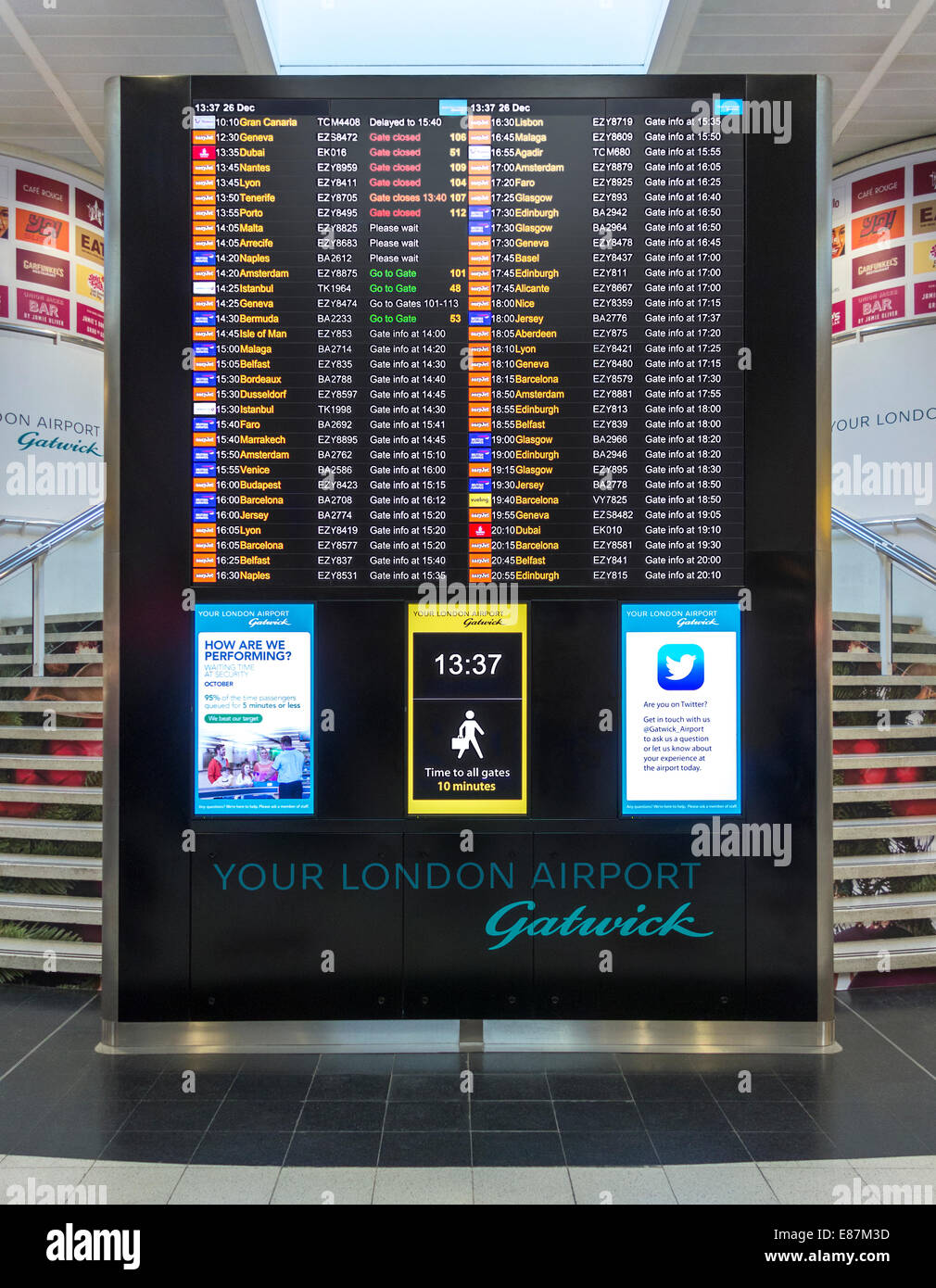 London Gatwick North Terminal Gates Info und Flug Anzeigentafel. Walking Strecken Zeichen, Uhr, Twitter Ankündigung. Stockfoto