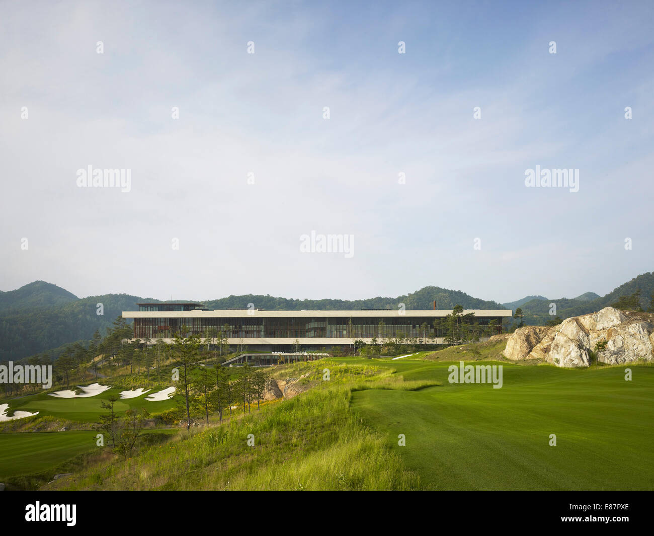 Pfeifen Sie Rock Golf-Clubhaus, Chuncheon, Südkorea. Architekt: Mecanoo, 2012. Längliche Clubhaus auf Bergrücken. Stockfoto