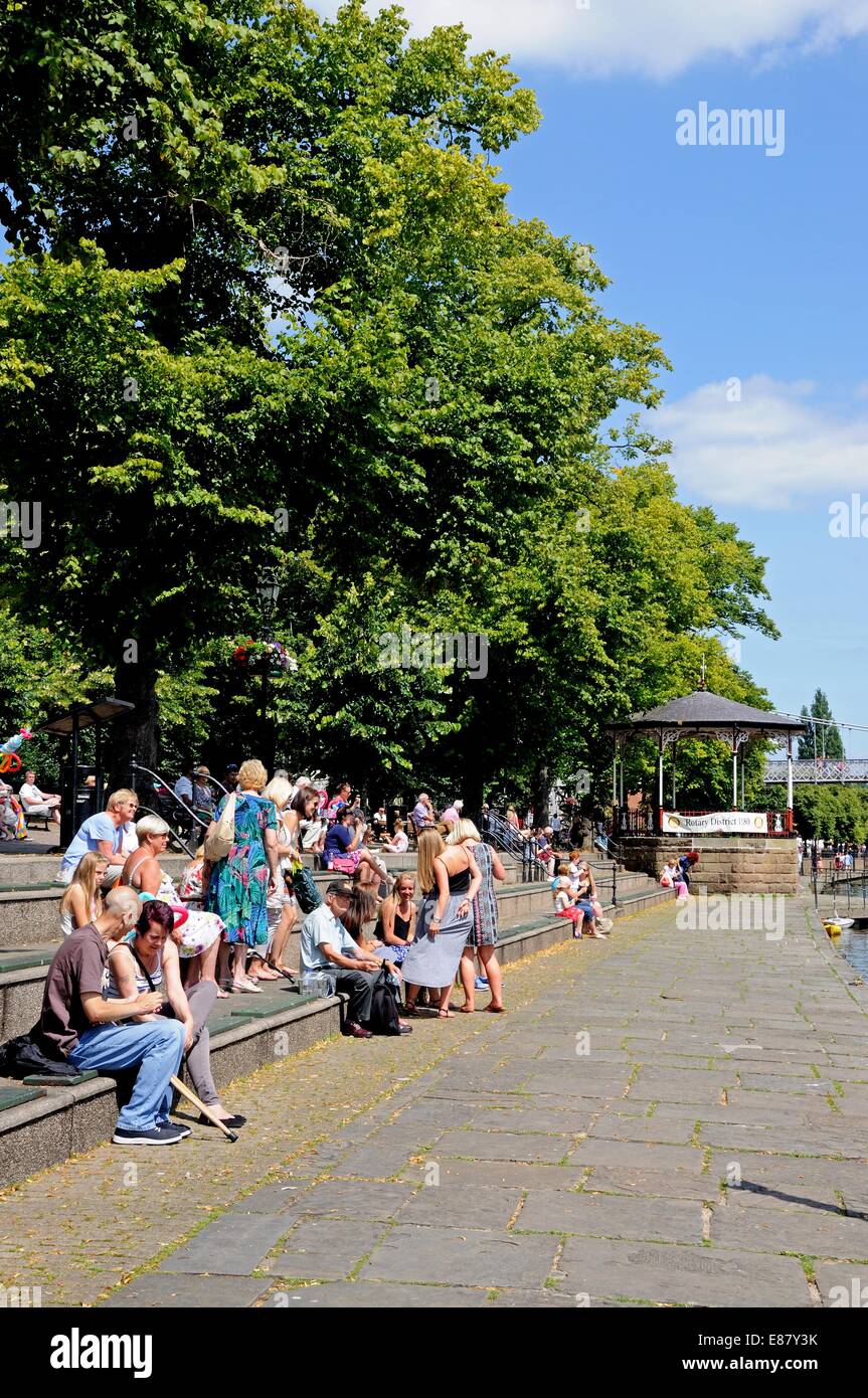 Touristen sitzen am Fluss Dee Ufer genießen den Sommer Sonnenschein, Chester, Cheshire, England, Vereinigtes Königreich, West-Europa. Stockfoto