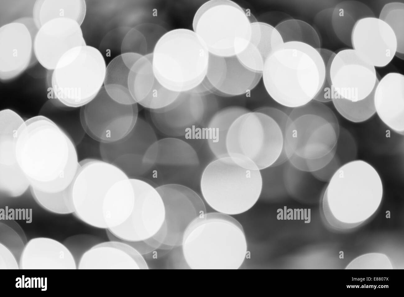 Erstellt durch eine Reihe von schwarzen und weißen Bokeh Hintergrund unscharf gestellt Weihnachtsbeleuchtung. Stockfoto
