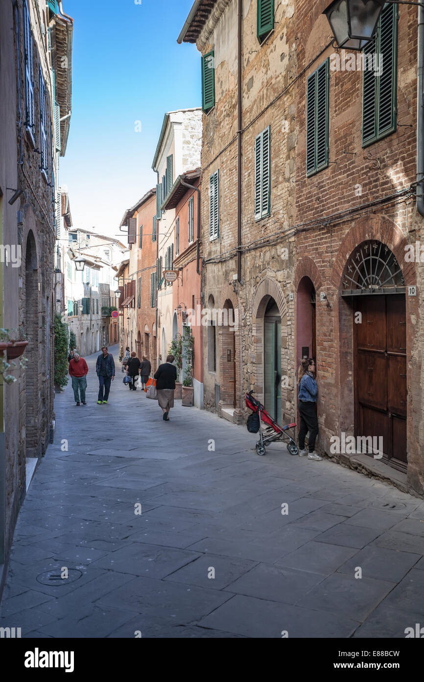 Bewohner von Montalcino zu Fuß durch schmale Straße am Morgen Stockfoto