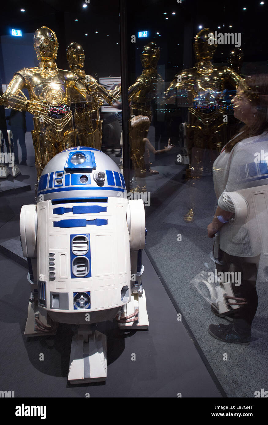 Bonn, Deutschland. 2. Oktober 2014. Ein Museums-Mitarbeiter schaut die (wieder) C3PO und R2D2 aus dem Film StarWars in der Ausstellung "Outer Space" in der Bundeskunsthalle in Bonn, Deutschland, 2. Oktober 2014. Die Ausstellung dauert bis zum 22. Februar 2015. Bildnachweis: Dpa picture Alliance/Alamy Live News Stockfoto