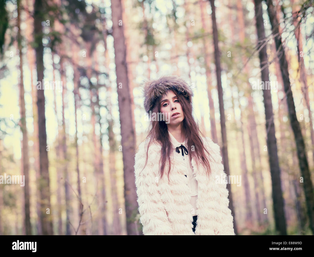 Modische schöne Frau im Wald - warm getönt Bild Stockfoto