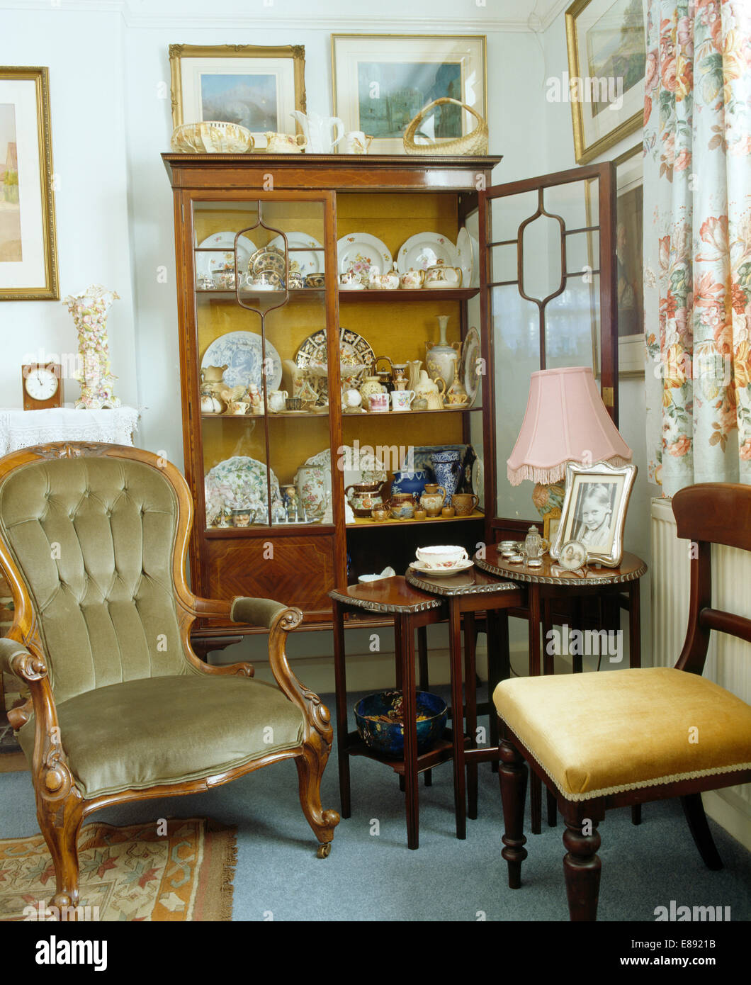 Vevlet gepolsterte Sessel und Nest-des-Tables in Ecke Esszimmer mit Antikglas vorderen Schrank Stockfoto