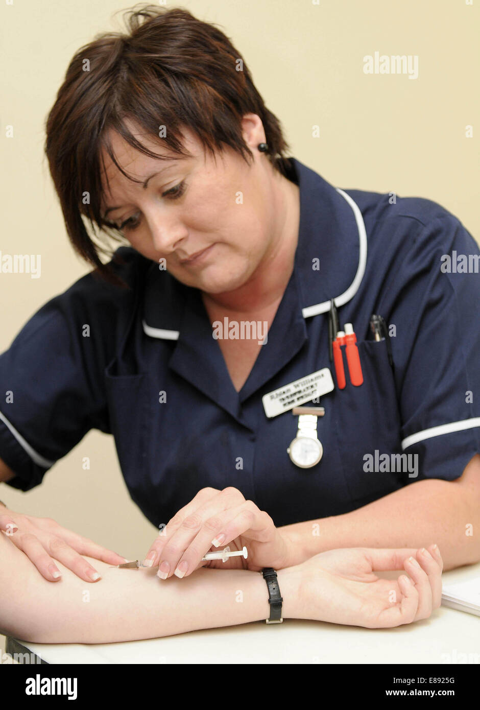 Eine Krankenschwester verwaltet einen Impfstoff mittels Injektion zu einem Patienten in einem medizinischen Zentrum im Rhondda, South Wales. Stockfoto