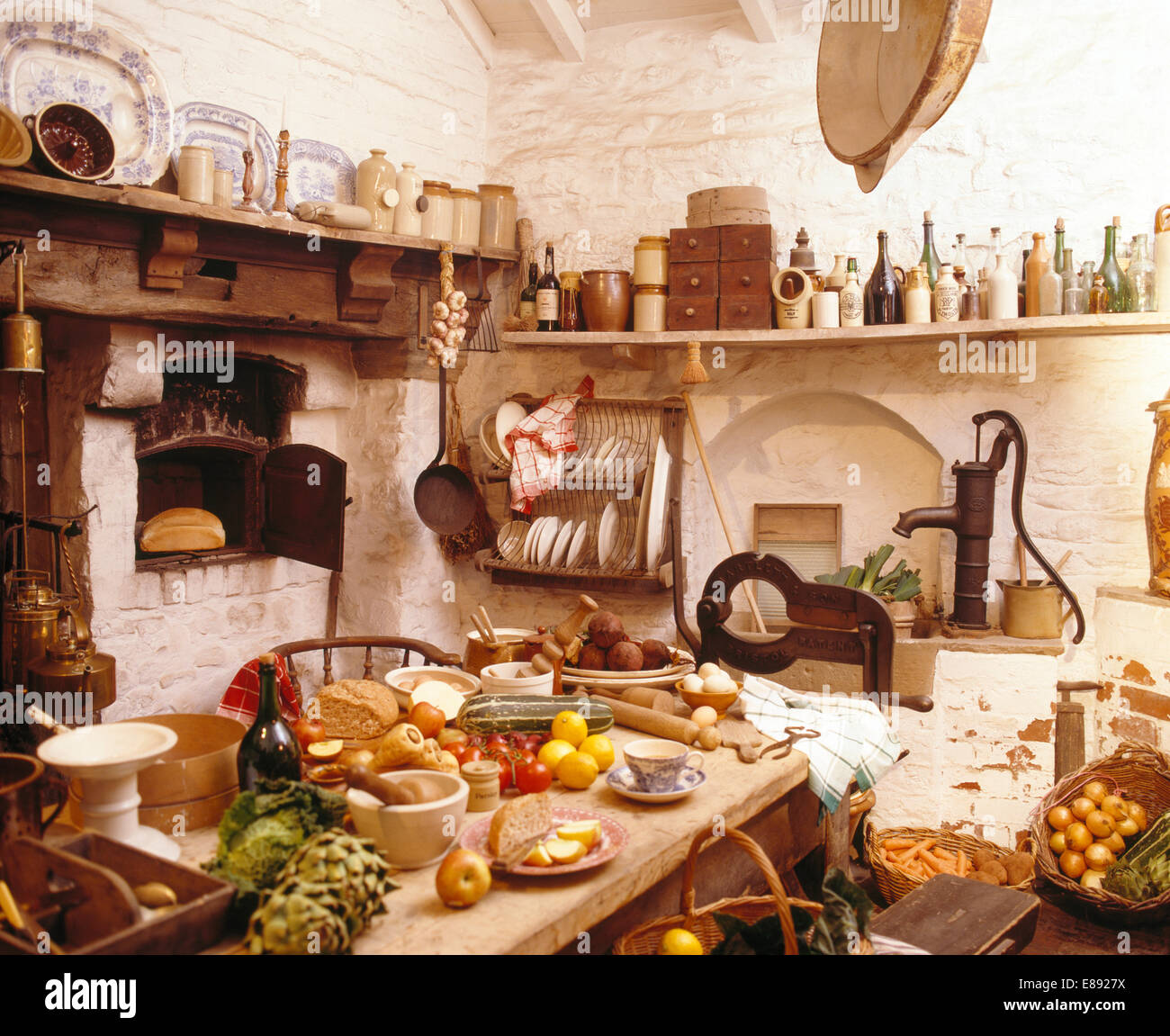 Tisch mit Essen in überfüllten alten altmodischen Küche Stockfoto