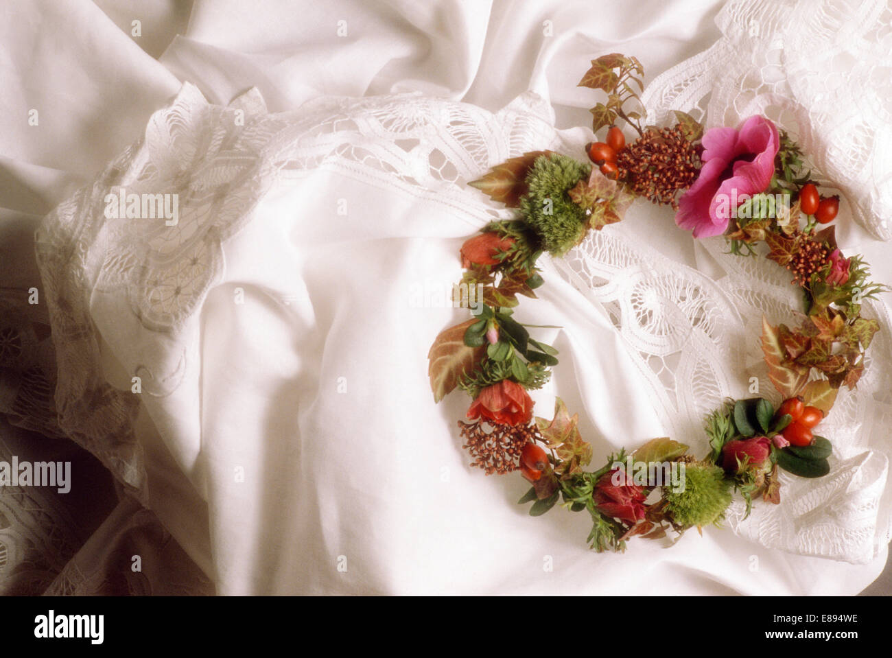 Stillleben mit Blumenkranz auf Spitze Kanten Stoff Stockfoto