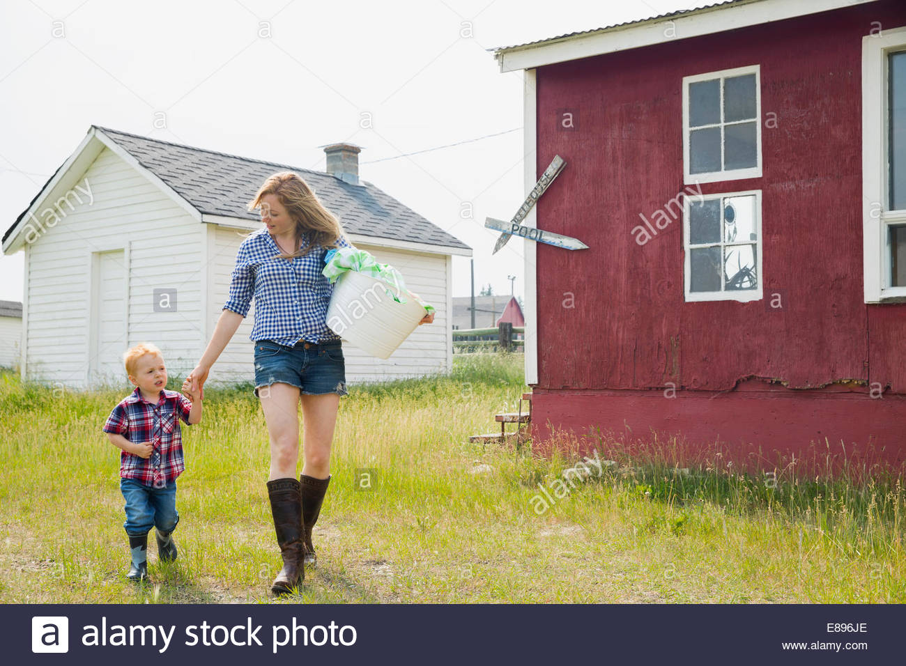 Mutter und Sohn tragen Wäsche vor Haus Stockfoto