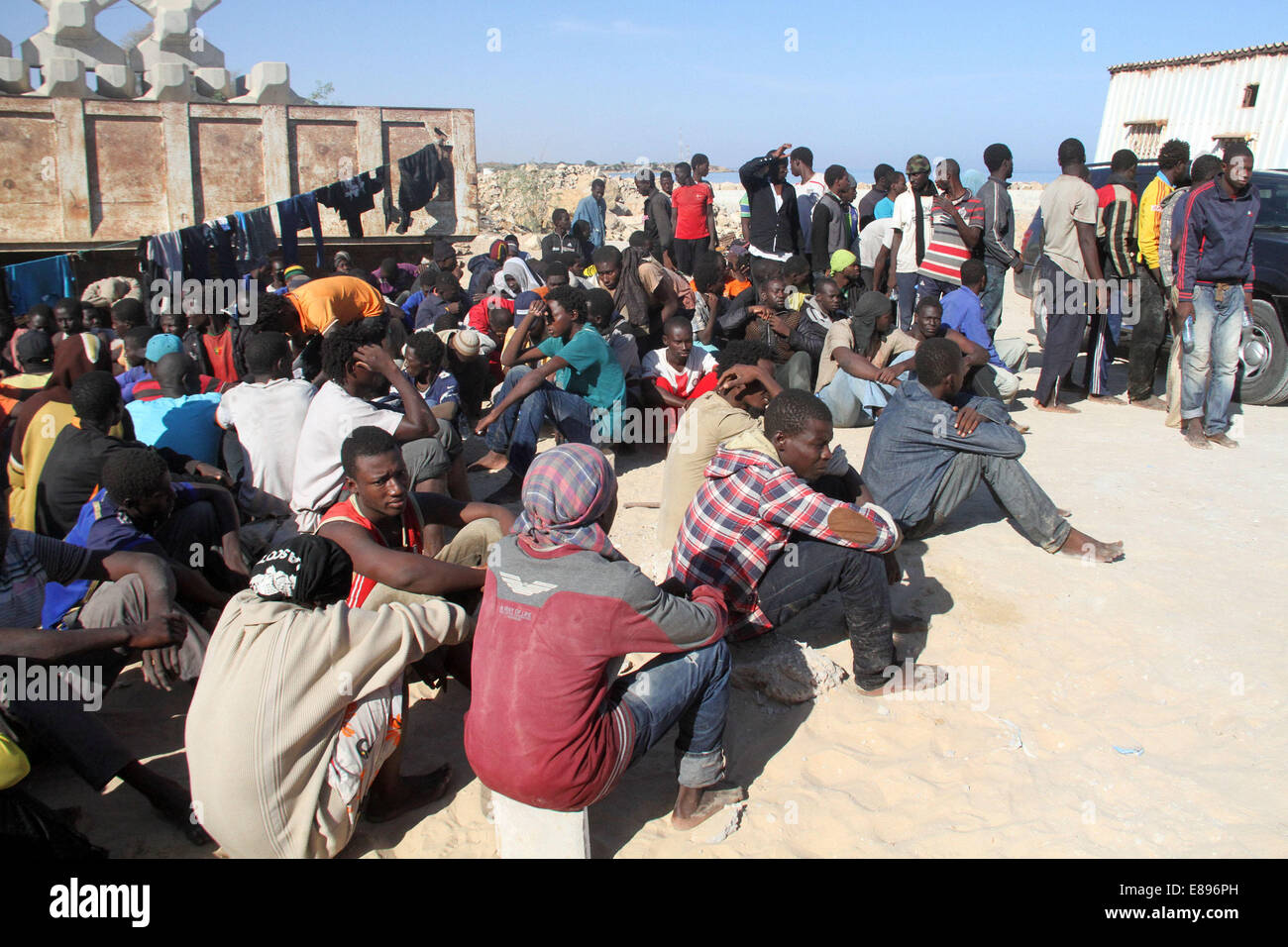 Garabulli, Libyen. 2. Oktober 2014. Einige illegale Einwanderer sitzen in einem Hof in Garabulli, Libyen, auf 2. Oktober 2014. Libyens Küstenwache am Donnerstag gerettet etwa 190 illegale Einwanderer in der Nähe der Küste Stadt Garabulli, etwa 60 Kilometer von Tripolis. Libyen ist seit langem ein Durchgangsort für Migranten, Malta, Italien und anderswo in Europa wegen seiner Nähe zu erreichen und relativ locker Grenzkontrollen. © Hamza Türkei/Xinhua/Alamy Live-Nachrichten Stockfoto
