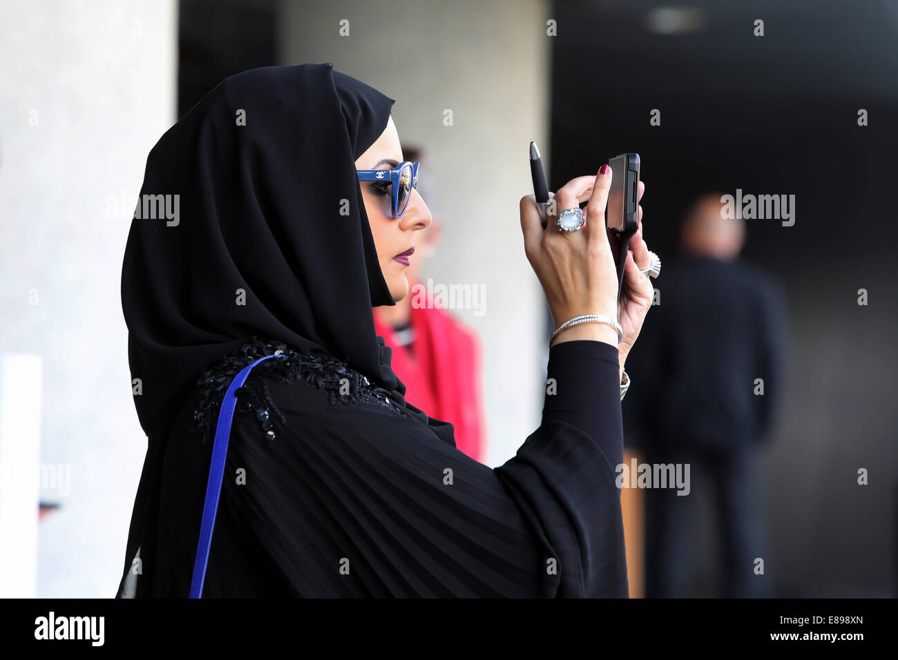 Dubai, Vereinigte Arabische Emirate, nimmt Frau in Tracht ein Foto mit ihrer Digitalkamera Stockfoto