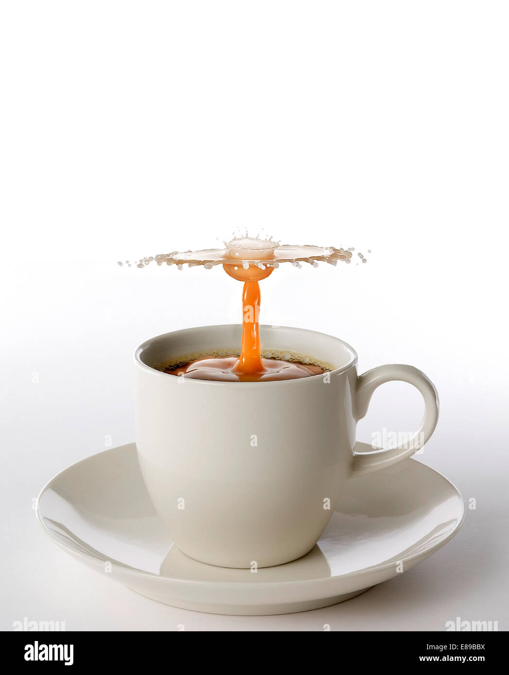 Kaffee und Sahne in Espresso Kaffee Tasse kollidieren, wodurch ein Fluid Design und Form. Stockfoto