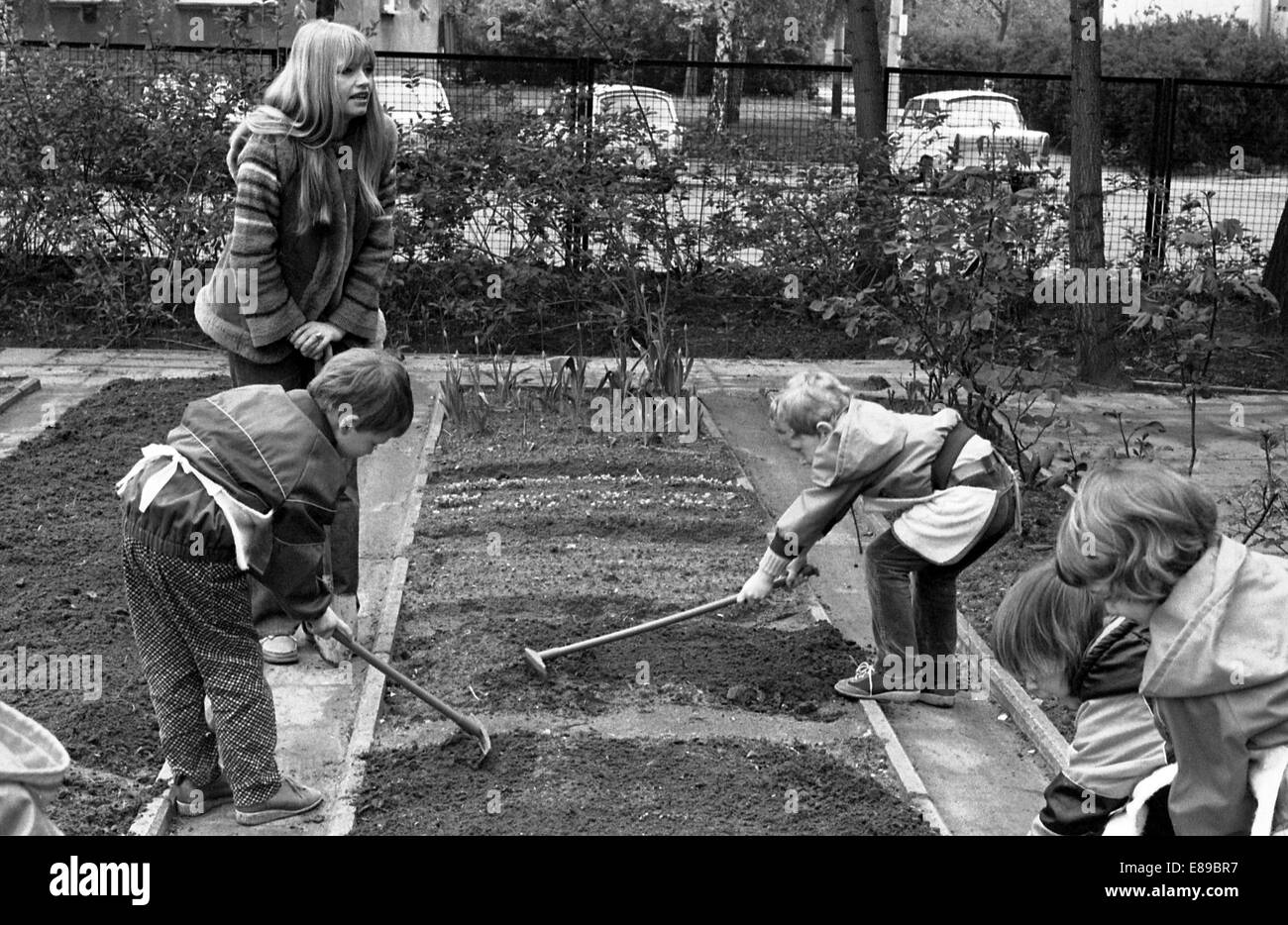 Berlin, DDR, Kinder im Vorschulalter und Lehrer arbeiten im Garten im Garten Schule Stockfoto