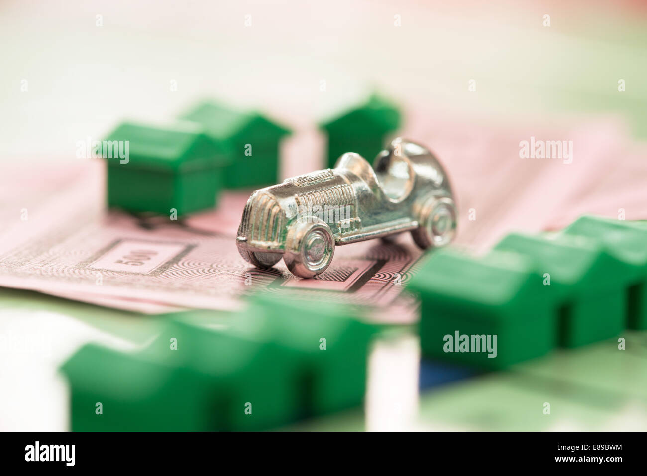 Der Monopol Auto Spielstein auf Yhe Spiele Geld mit defokussierten Häuser auf th-board Stockfoto