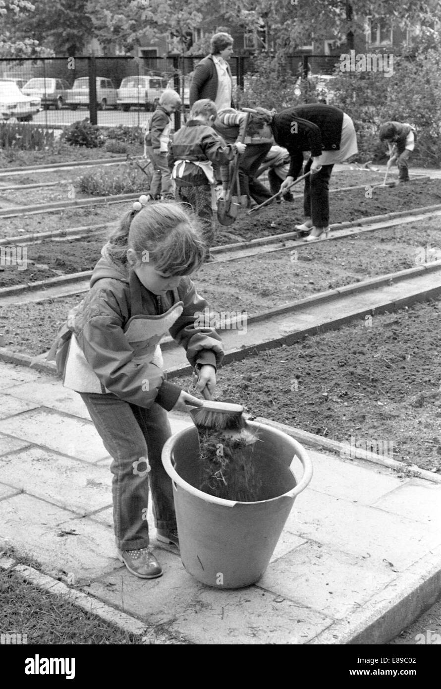Berlin, DDR, Kinder im Vorschulalter und Lehrer arbeiten im Garten im