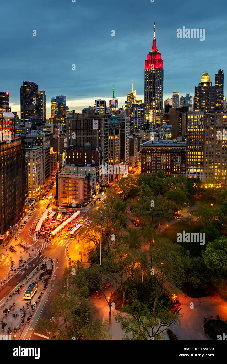 Flatiron District, Fifth Avenue und Broadway mit dem Empire State Building in rot und weiß beleuchtet. Stockfoto