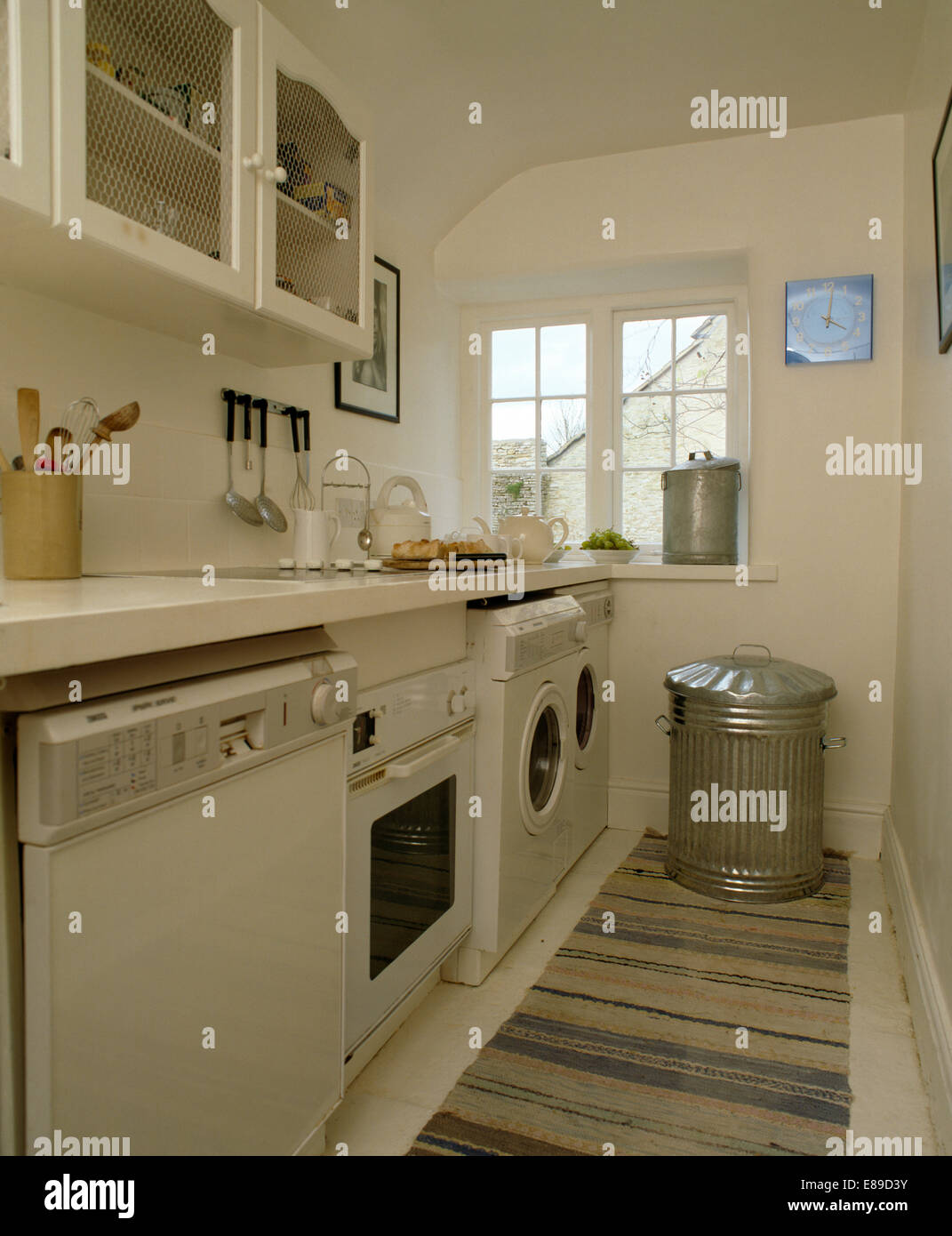 Geschirrspüler und Backofen mit Waschmaschine in Zeile der Geräte in weiße Küche mit verzinkten bin Stockfoto