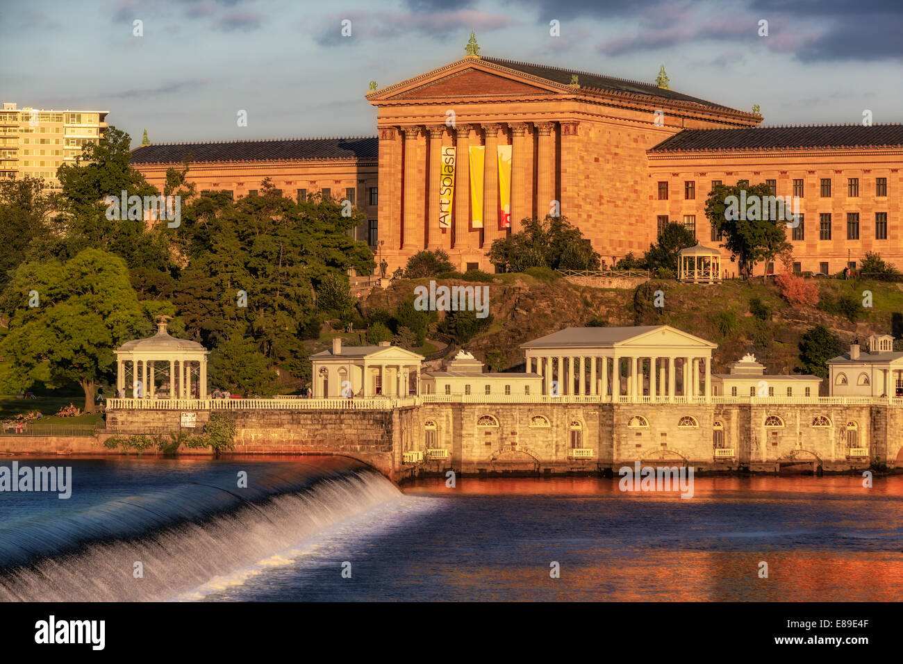 Philadelphia Museum of Art - Westblick auf das Philadelphia Museum of Art während der magischen Stunde des Sonnenuntergangs. Das warme goldene Licht der untergehenden Sonne spiegelt sich in der Architektur, im Fairmount Park und im Wasser des Fairmount Water Works am Schuylkill River Damm im Vordergrund wider. Das Philadelphia Museum of Art gehört zu den größten Kunstmuseen in den Vereinigten Staaten. Das Philadelphia Museum of Art ist nicht nur für seine Architektur und Sammlungen bekannt, sondern auch für seine Rolle in den Rocky Films – Rocky (1976) und vier seiner fünf Fortsetzungen, II, III, V und Rocky Balboa, bekannt Stockfoto