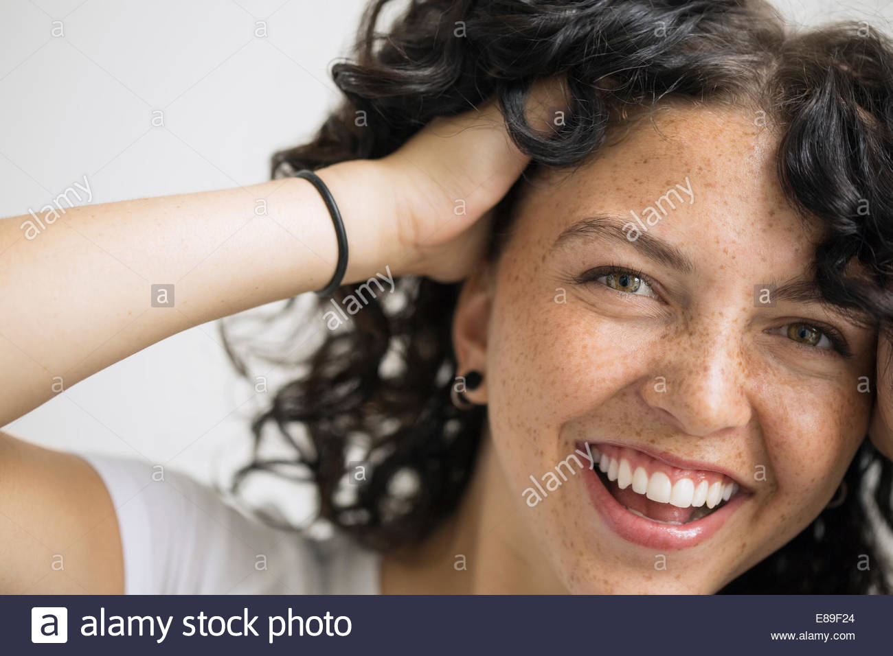 Porträt der lächelnde Frau mit Händen in Haar Stockfoto