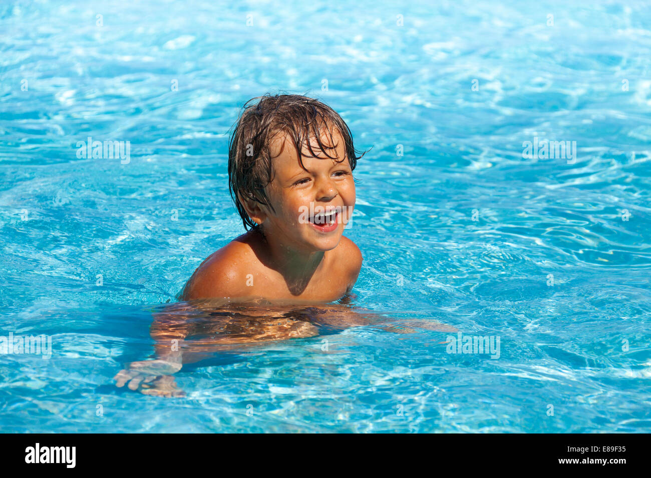 Lachender Junge mit positiven Emotionen Schwimmen im pool Stockfoto
