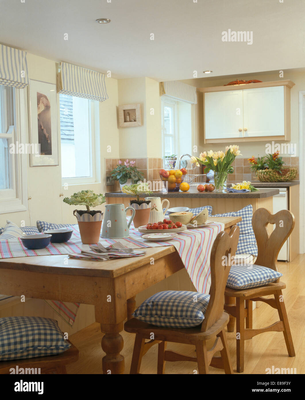 Blaue aufgegebenes Kissen auf alte Kiefer Stühle am Tisch für Frühstück in küstennahen Küche Esszimmer Stockfoto