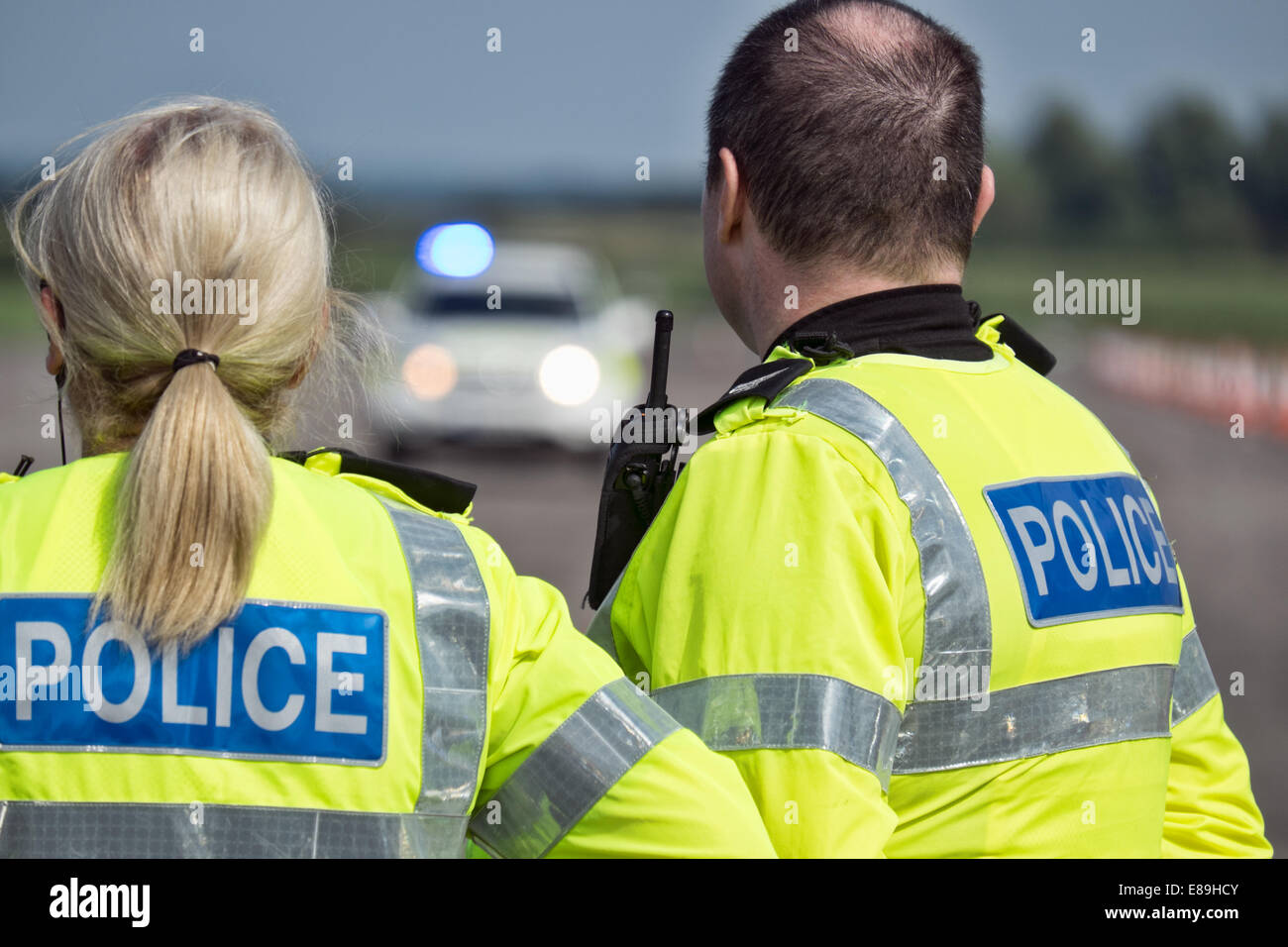 Uniformierte britische Polizisten warten auf die Ankunft ihrer Kollegen bei einem Zwischenfall Stockfoto