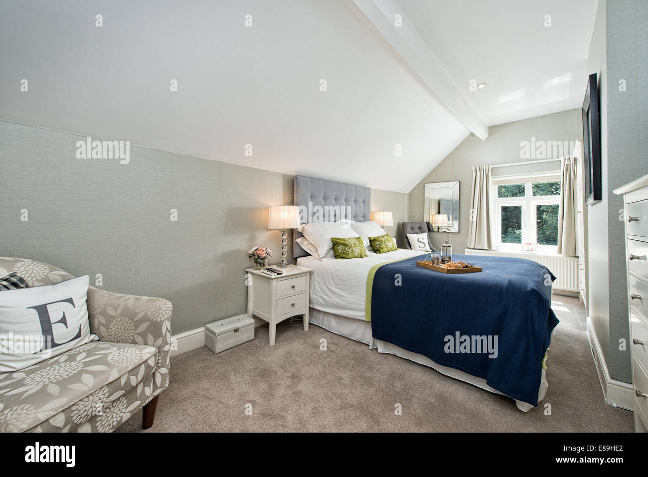 Frühstück im Bett in einem komfortablen zeitgenössische Doppel Schlafzimmer dekoriert in Blues & grau Stockfoto