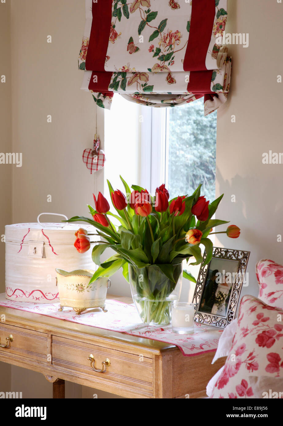 Floral Blind auf Fenster oben Schminktisch mit Vase mit roten Tulpen und gerahmte Fotografie Stockfoto