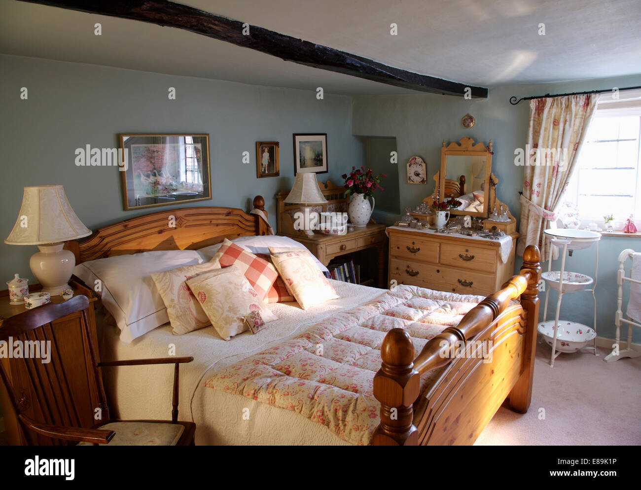 Eiderdaune auf Kiefer Bett mit Haufen von Kissen in blass grau Land Schlafzimmer Stockfoto