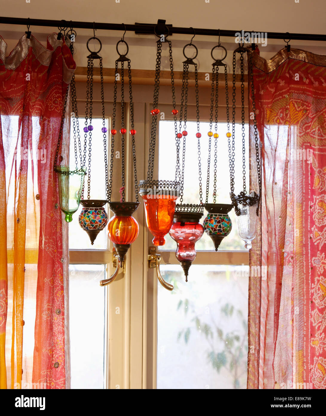 Nahaufnahme von Mosaik und rot Glas marokkanischen Laternen auf Fenster mit roten Sari Gewebevorhänge Stockfoto