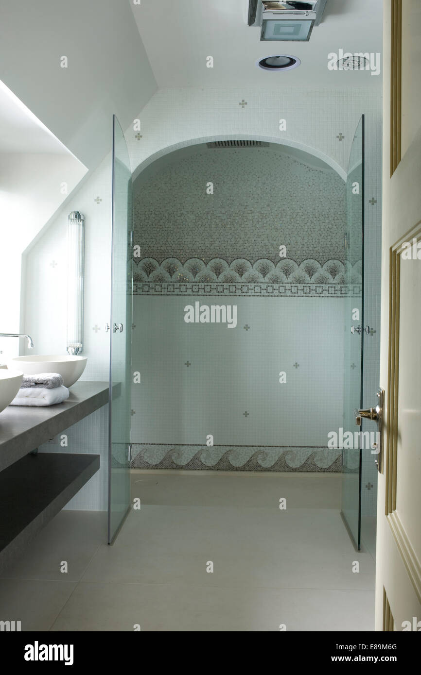 Doppelte Glastüren zu Mosaik gefliesten Duschbereich im Bad Stockfoto