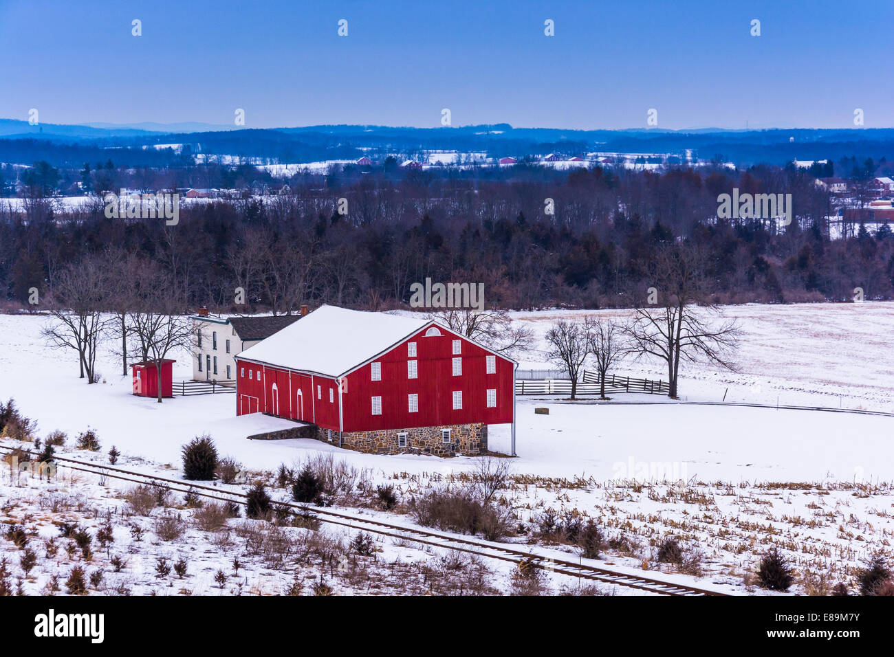 Blick auf eine rote Scheune in einem schneebedeckten Feld in Gettysburg, Pennsylvania. Stockfoto
