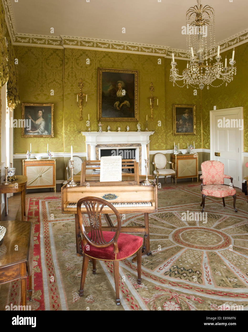 Spinett und antike Möbel im Land Haus Salon mit grünem Damast-Tapete Stockfoto