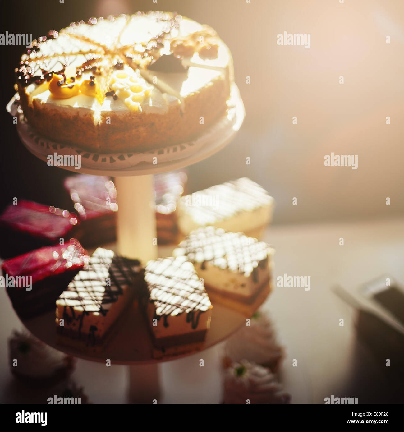 Verschiedene leckere Kuchen. Schokolade, Beere, Biskuit. Catering, Party-Konzept. Verschwommenes Bild getönt in warmen Farben mit Rückwirkung Stockfoto